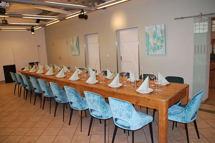 Eleganter Tagungsraum im EventCenter mit Holztisch und blauen Stühlen